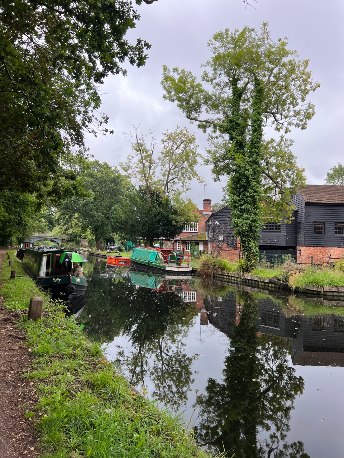A Holly narrowboat moored beside a converted mill